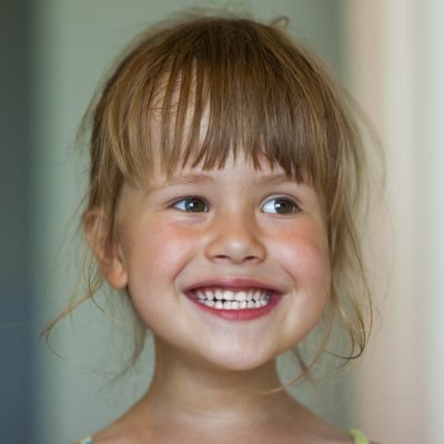 Portrait of a little smiling girl on blurred background